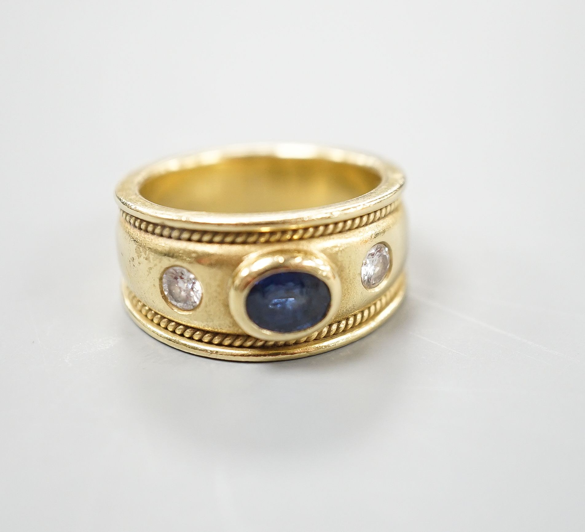 A modern yellow metal and collet set sapphire and diamond three stone ring, signed Charles Greig, size M, gross weight 11.5 grams.
